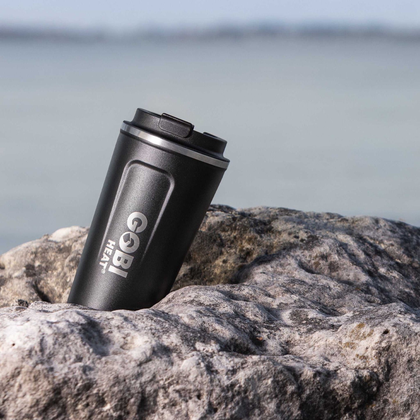 17oz stainless steel coffee mug with double-wall insulation on a rock.