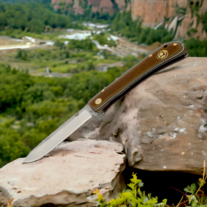 Kam Knife PR77 with 4116 steel blade and Micarta handle, outdoor pocket knife on rock.