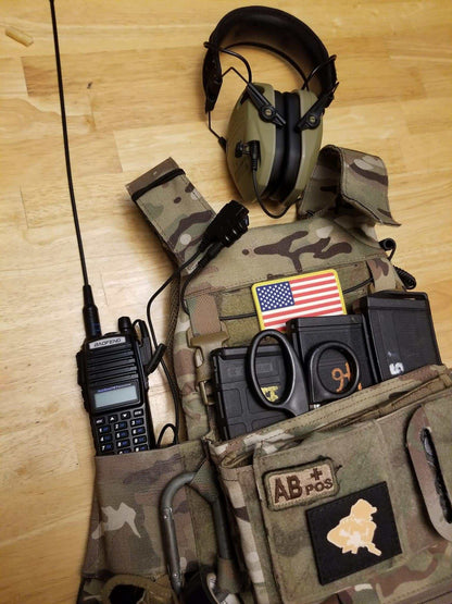 SMC Baofeng cable connected to radio and tactical gear with earmuffs.