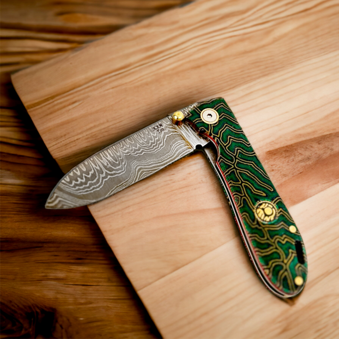 Kam Knife T20 with Damascus steel blade and green Micarta handle placed on wood surface.