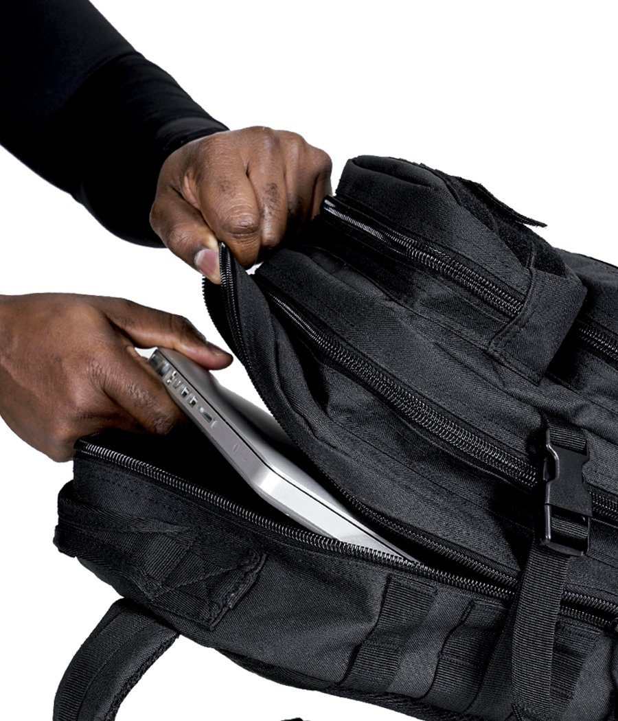 Person accessing laptop compartment in black Ultimate Assault Backpack - Sling Bag.