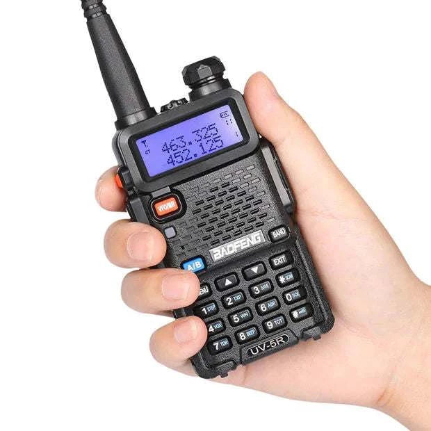 Baofeng UV5R 8 Watt Ham Radio held in hand with backlit display and keypad.