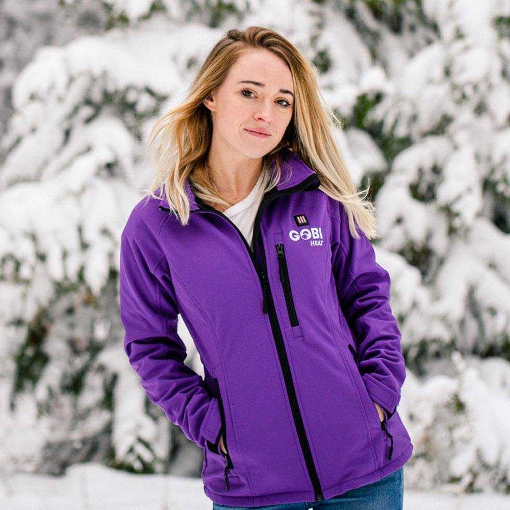 Sahara Womens Heated Jacket in purple with built-in heater, velcro cuffs, and multiple heat settings, snow background.