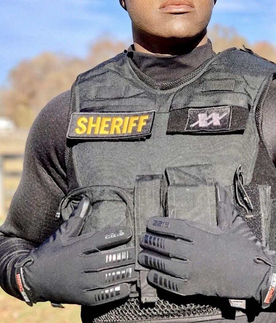 Tactical winter gloves with smart-touch fingertips worn by a sheriff.