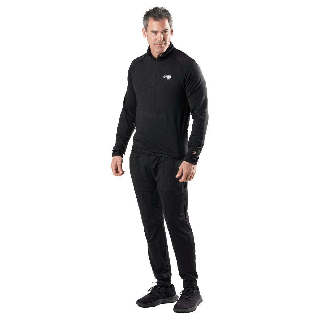 Man wearing Basecamp Men's Baselayer Pants, designed for warmth with conductive heating and flexible material.