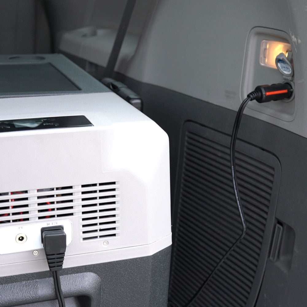 LionCooler DC 12V power cable connected to a portable refrigerator in a car.