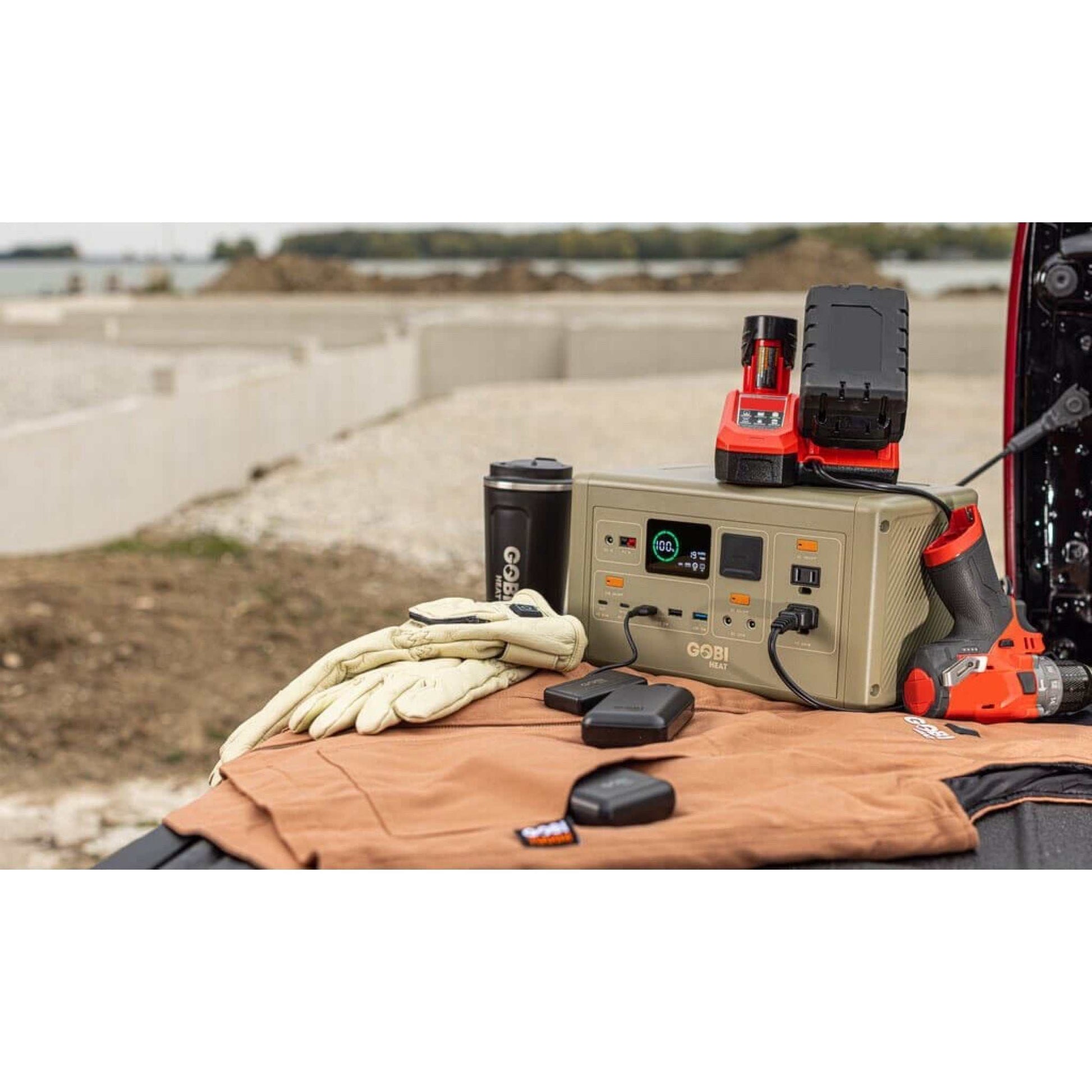 CORE 614W Portable Power Station with accessories on a truck bed, ideal for camping and emergency use.