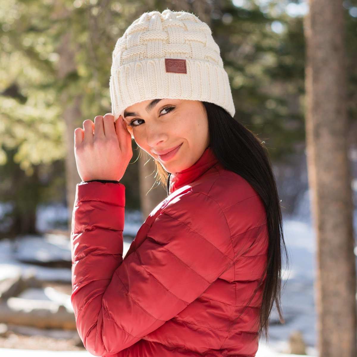 Crest Womens Heated Beanie in snowy outdoor setting, showcasing warmth and style.