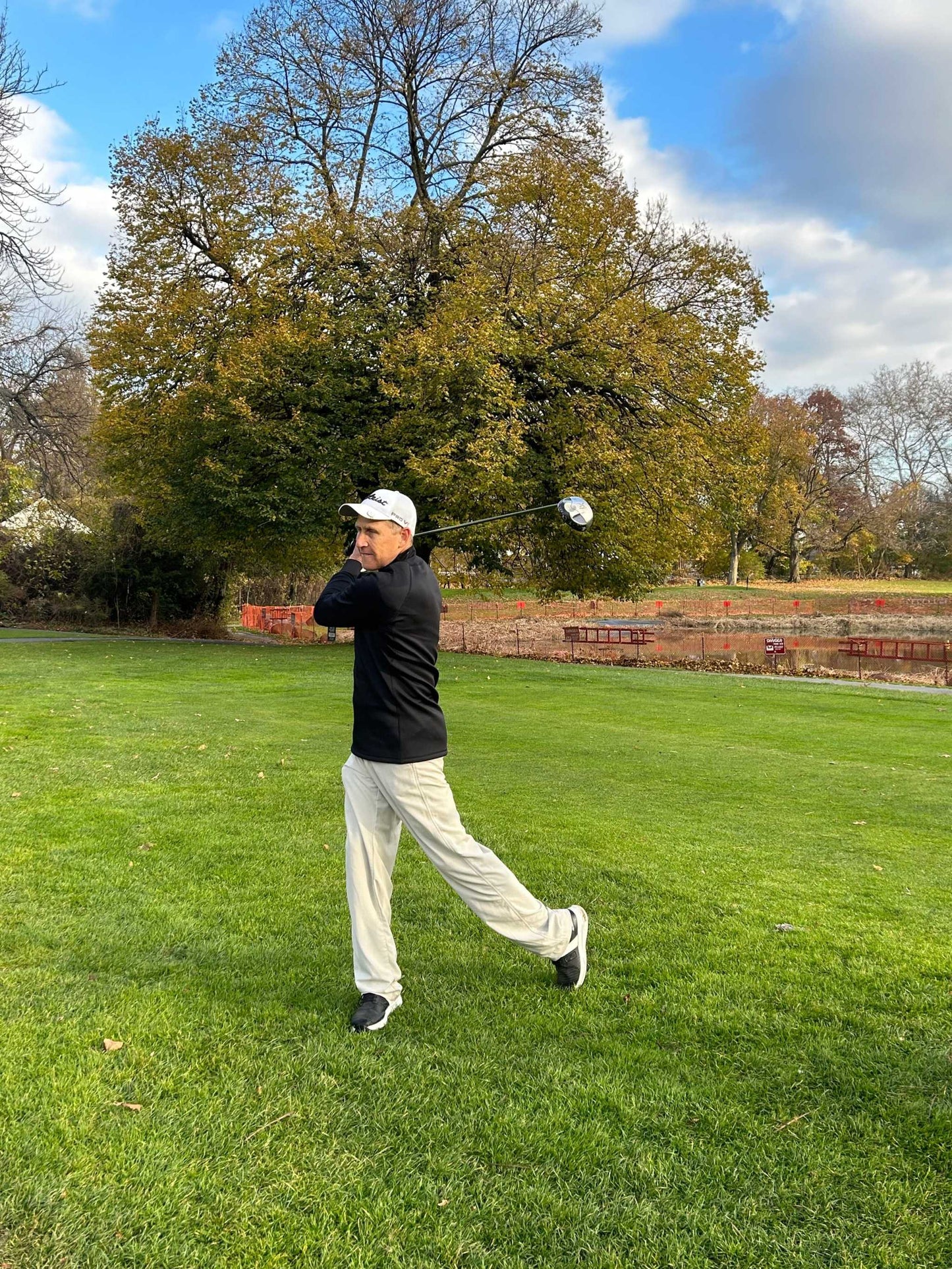 Golf player wearing Equinoxx K2 Dyna-Thermal shirt, swinging on a green field.