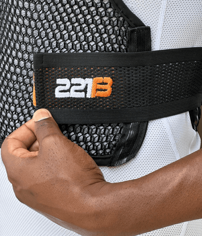 Close-up of a hand adjusting a Maxx-Dri Vest 5.0 strap, showcasing the mesh and velcro design for improved ventilation.