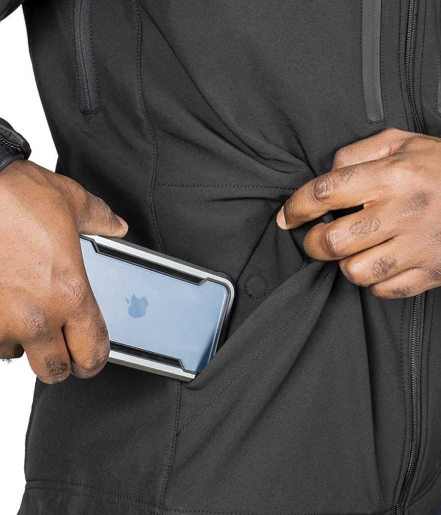 Man placing a phone in the pocket of a black Tradecraft Tactical Jacket 2.0.