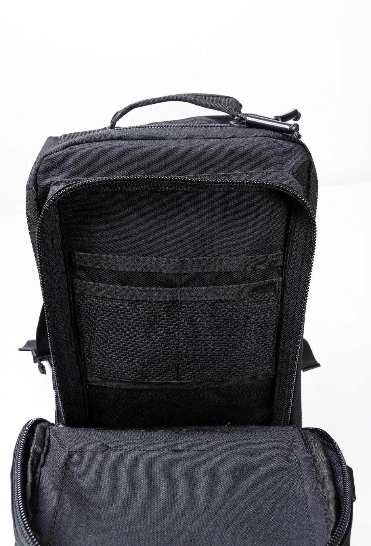 Black Ultimate Assault Backpack with open compartments showing internal pockets and storage space.