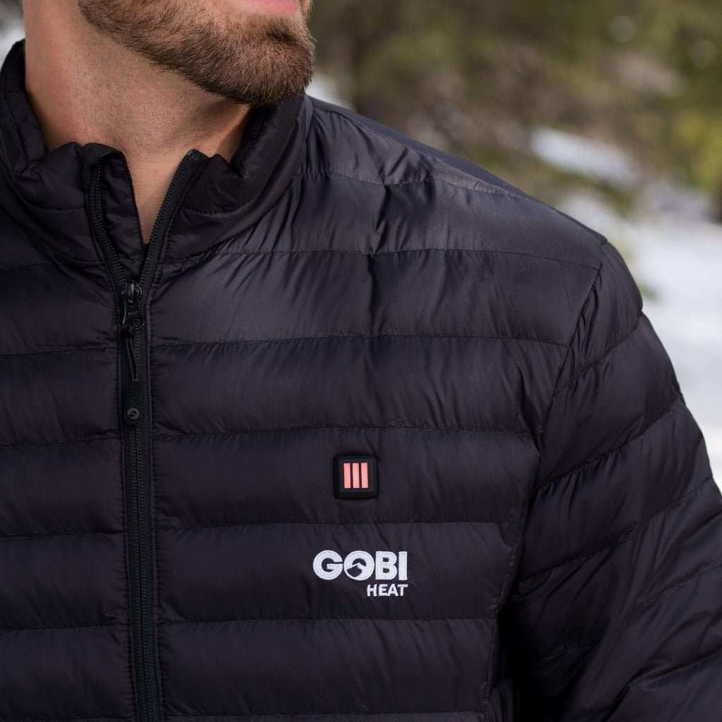 Man wearing a black Wolf Mens Heated Jacket with Gobi Heat logo.