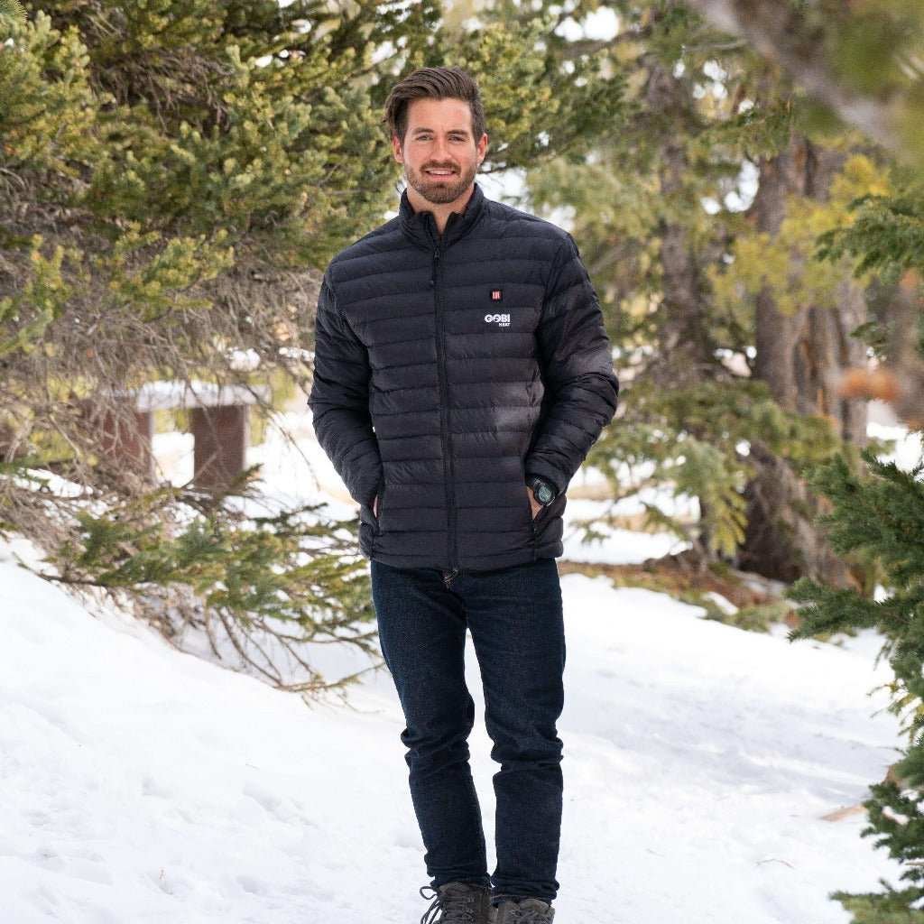 Man wearing Wolf Men's Heated Jacket in a snowy forest.