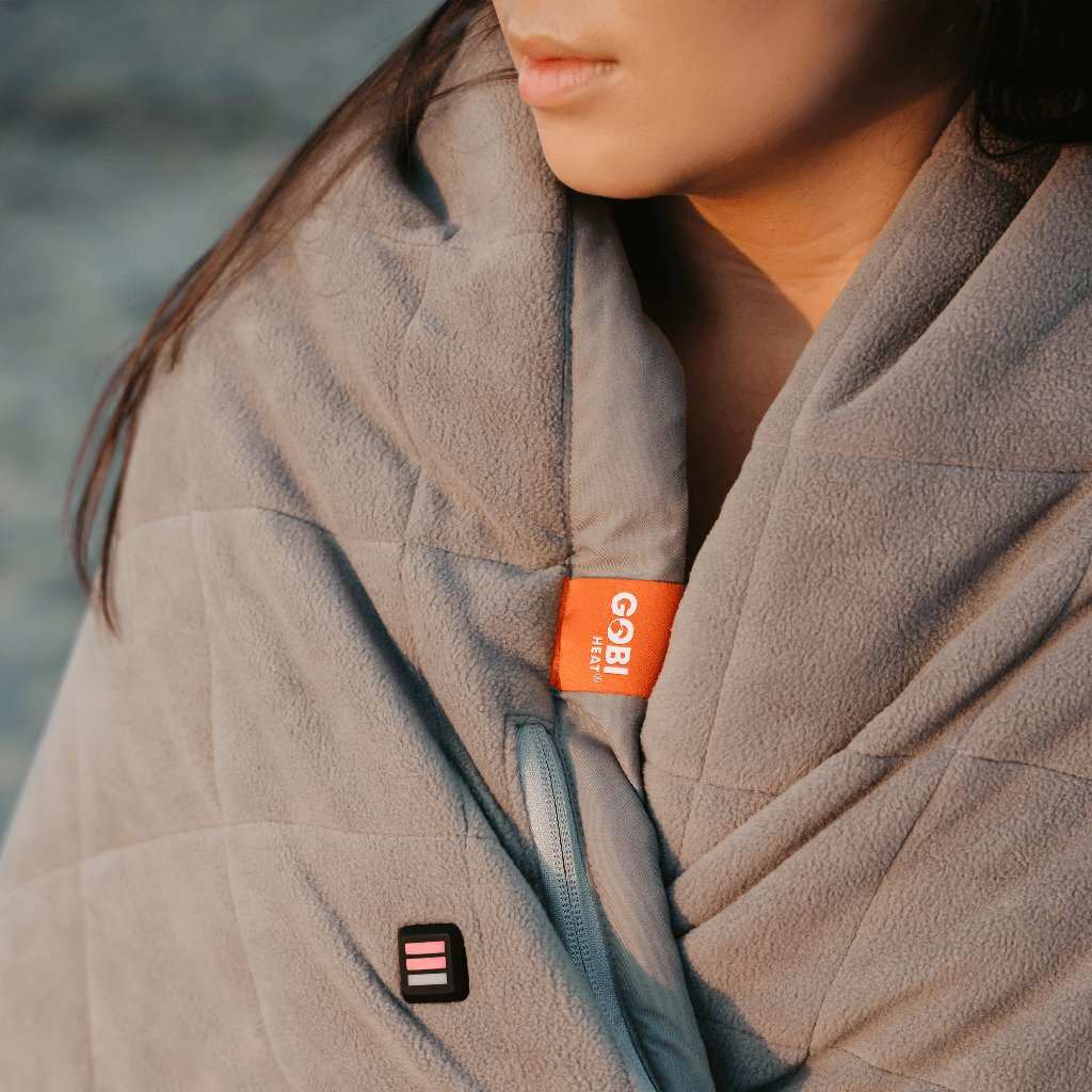 Zen Portable Heated Blanket wrapped around a person outdoors for warmth and comfort.