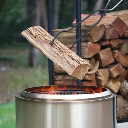 Solo Stove stainless steel fire pit tools with wood tongs in use.