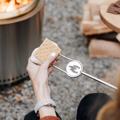 Solo Stove stainless steel fire pit tools tongs used for making s'mores by a fire pit.